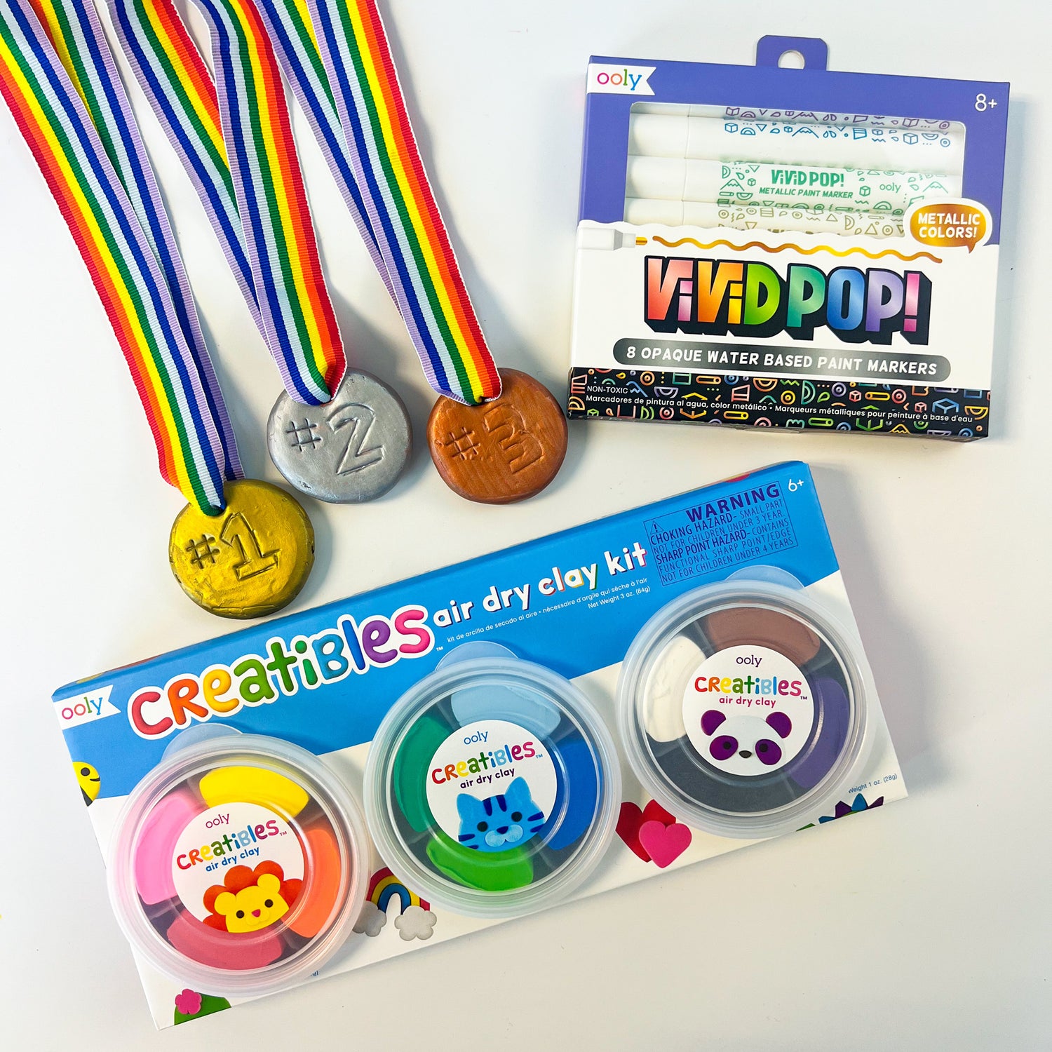 3 clay medals gold #1 silver #2 bronze #3 with rainbow ribbon and packages of OOLY Creatibles Air Dry Clay and Vivid! Pop Markers in Metallic