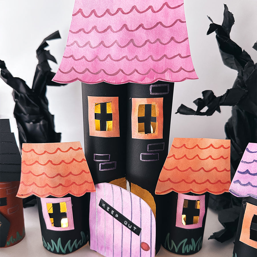 Pink, orange, and black haunted house made out of sketchbook paper and upcycled paper towel rolls