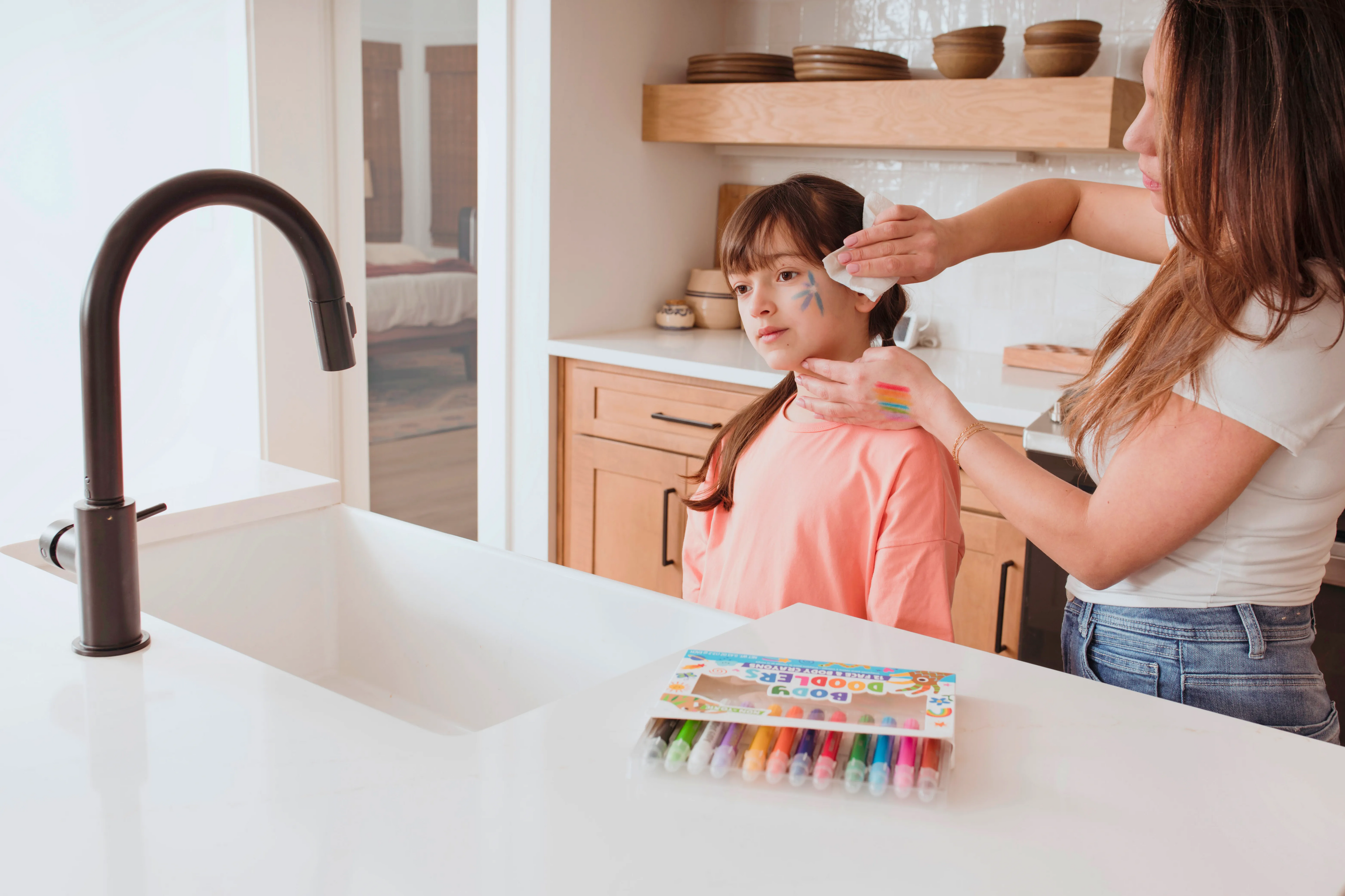 Woman cleaning girl's face from OOLY Body Doodlers - Face & Body Crayon