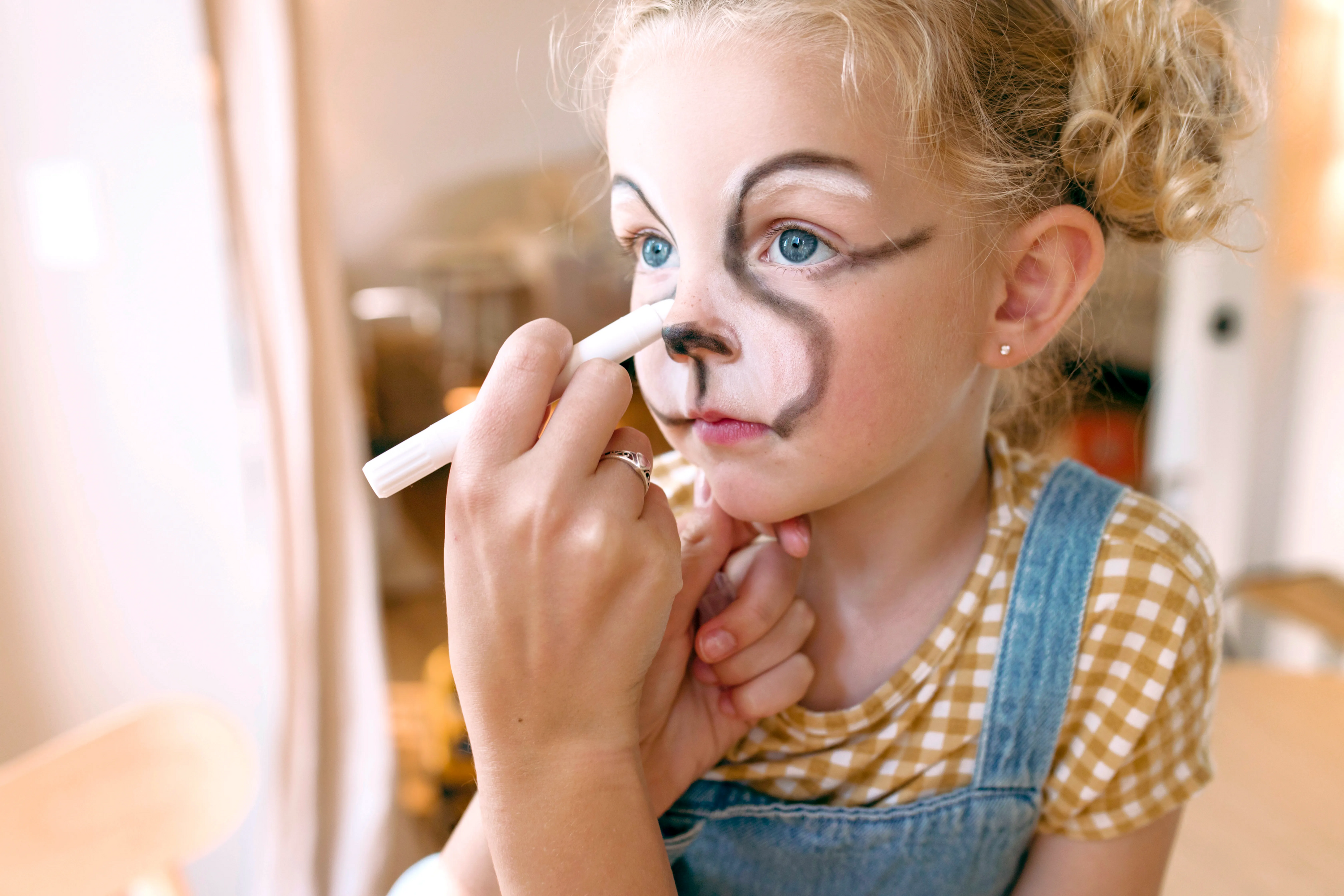 Close up of mother drawing animal face with OOLY Body Doodlers - Face & Body Crayons on little girl