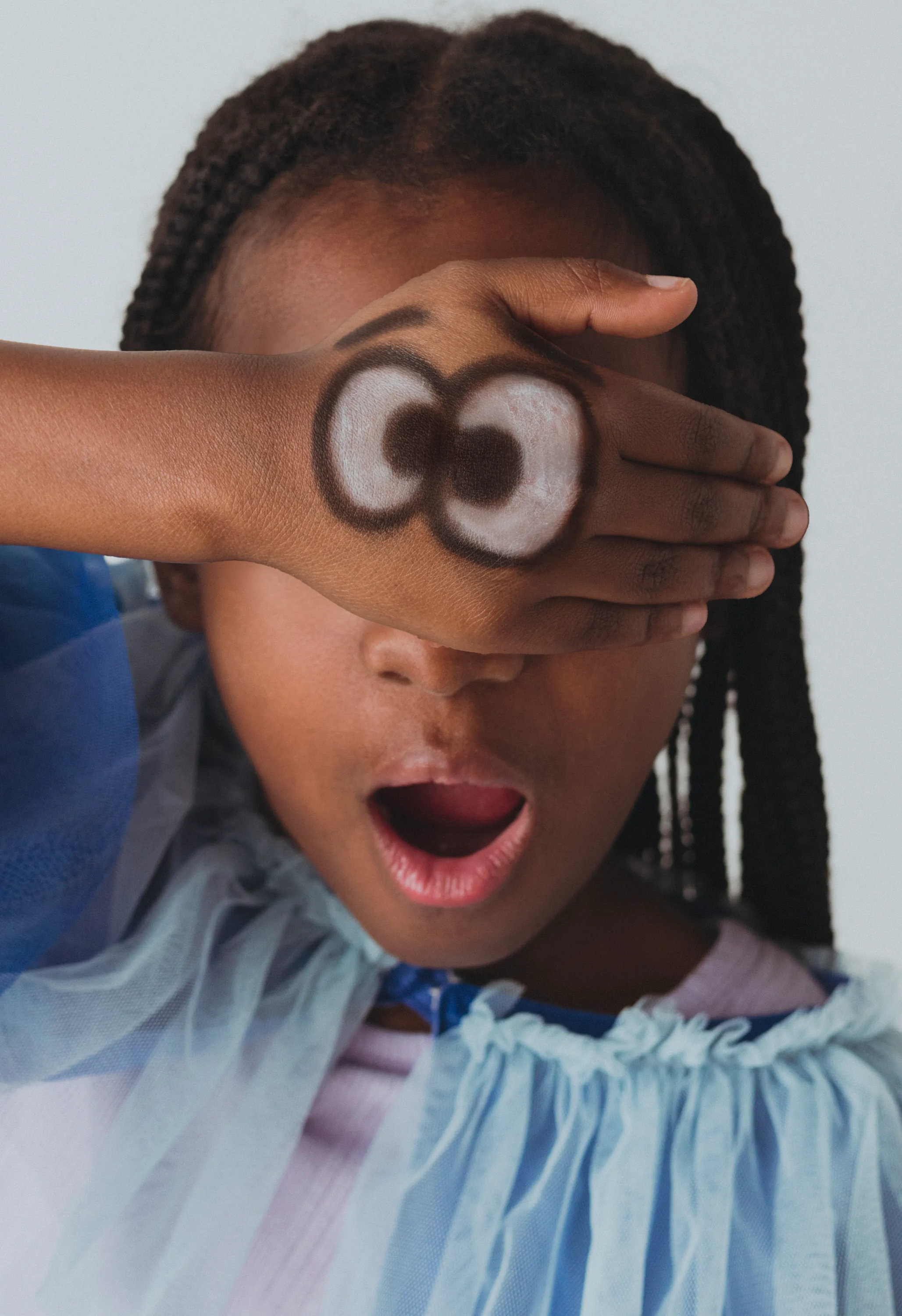 Girl with funny googly eyes on hand drawn with OOLY Body Doodlers covering her eyes