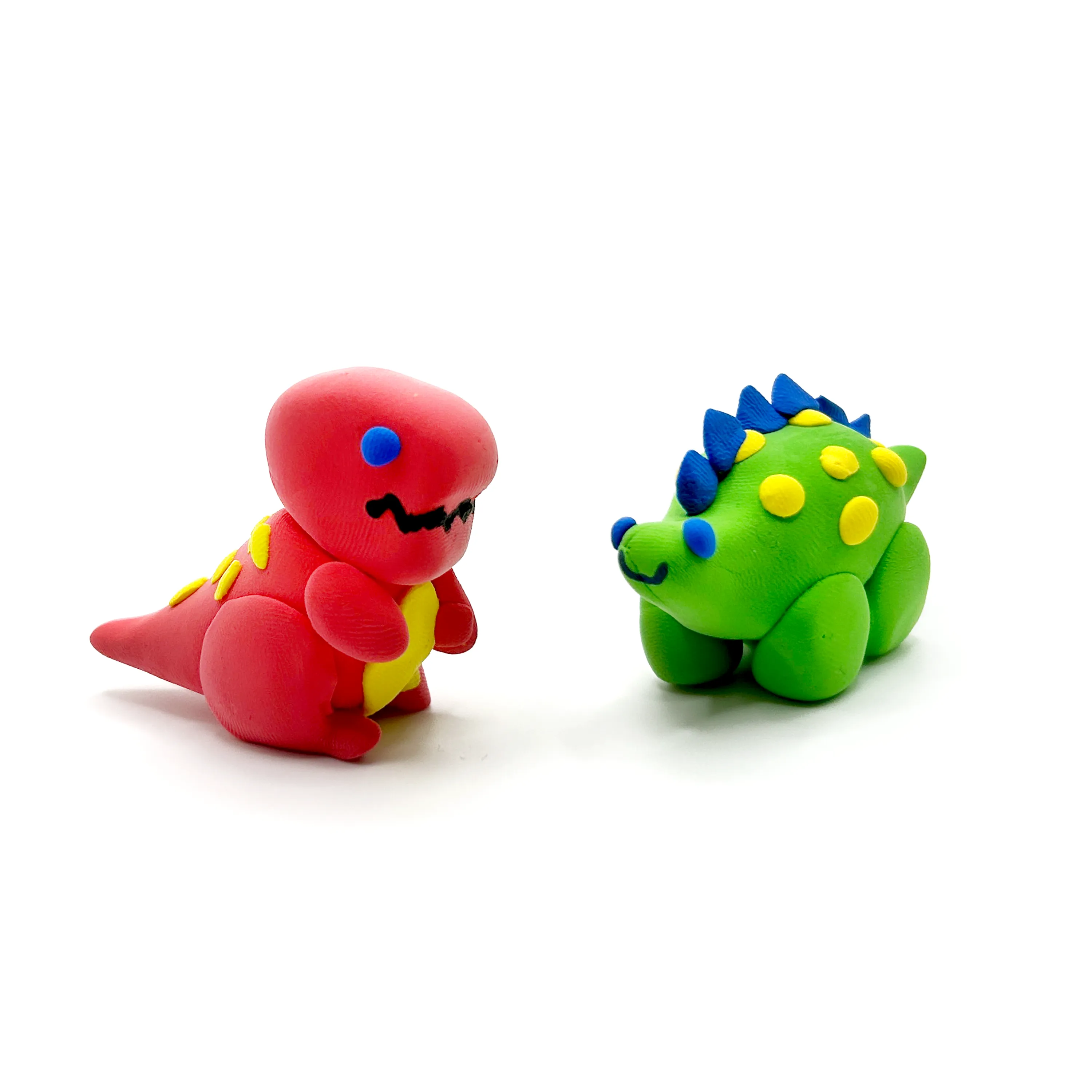 Two completed dinosaurs from OOLY Creatibles Mini Air Dry Clay Kit - Dino BFFs