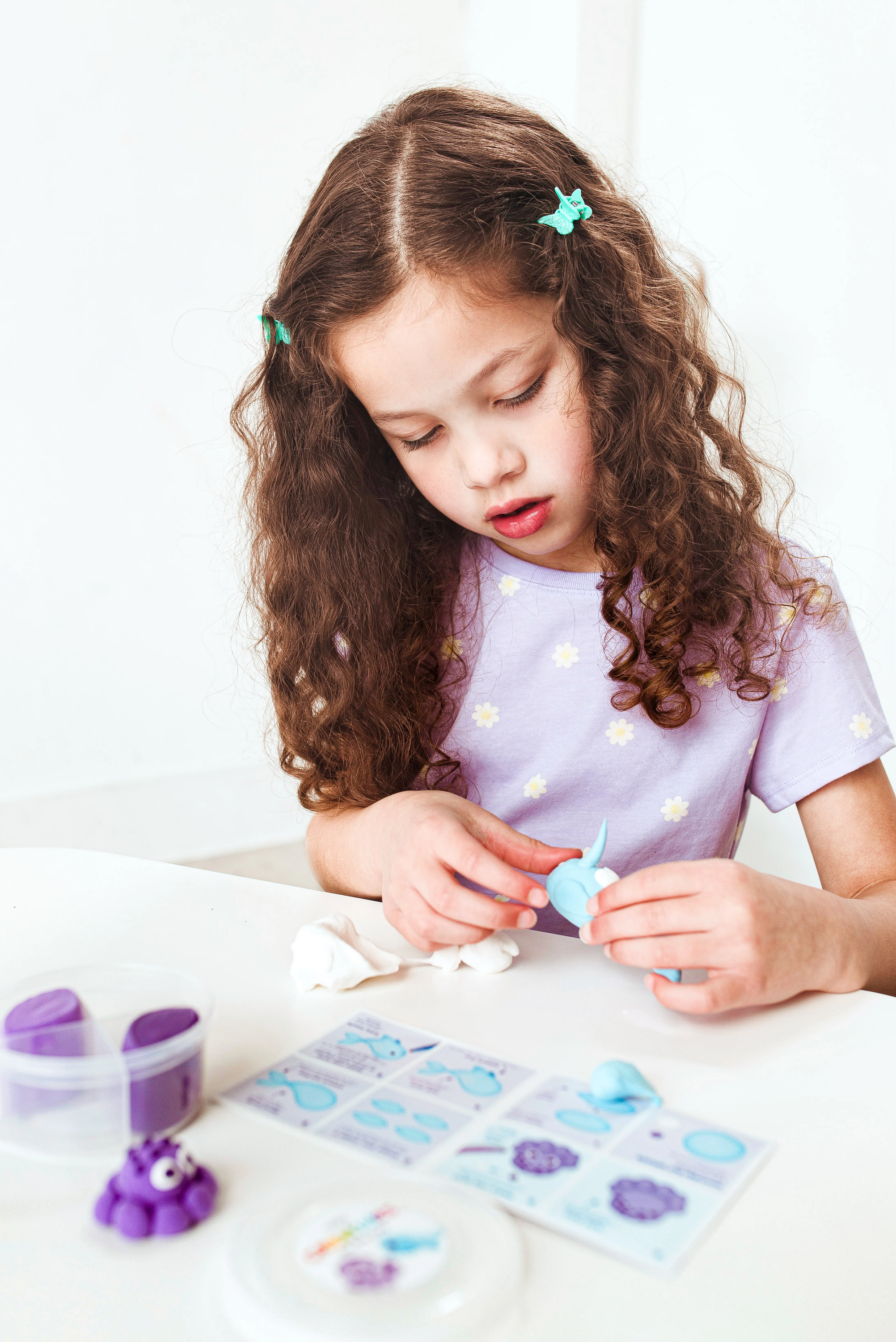 Girl making clay narwhal from OOLY Creatibles Mini Air Dry Clay Kit - Ocean BFFs