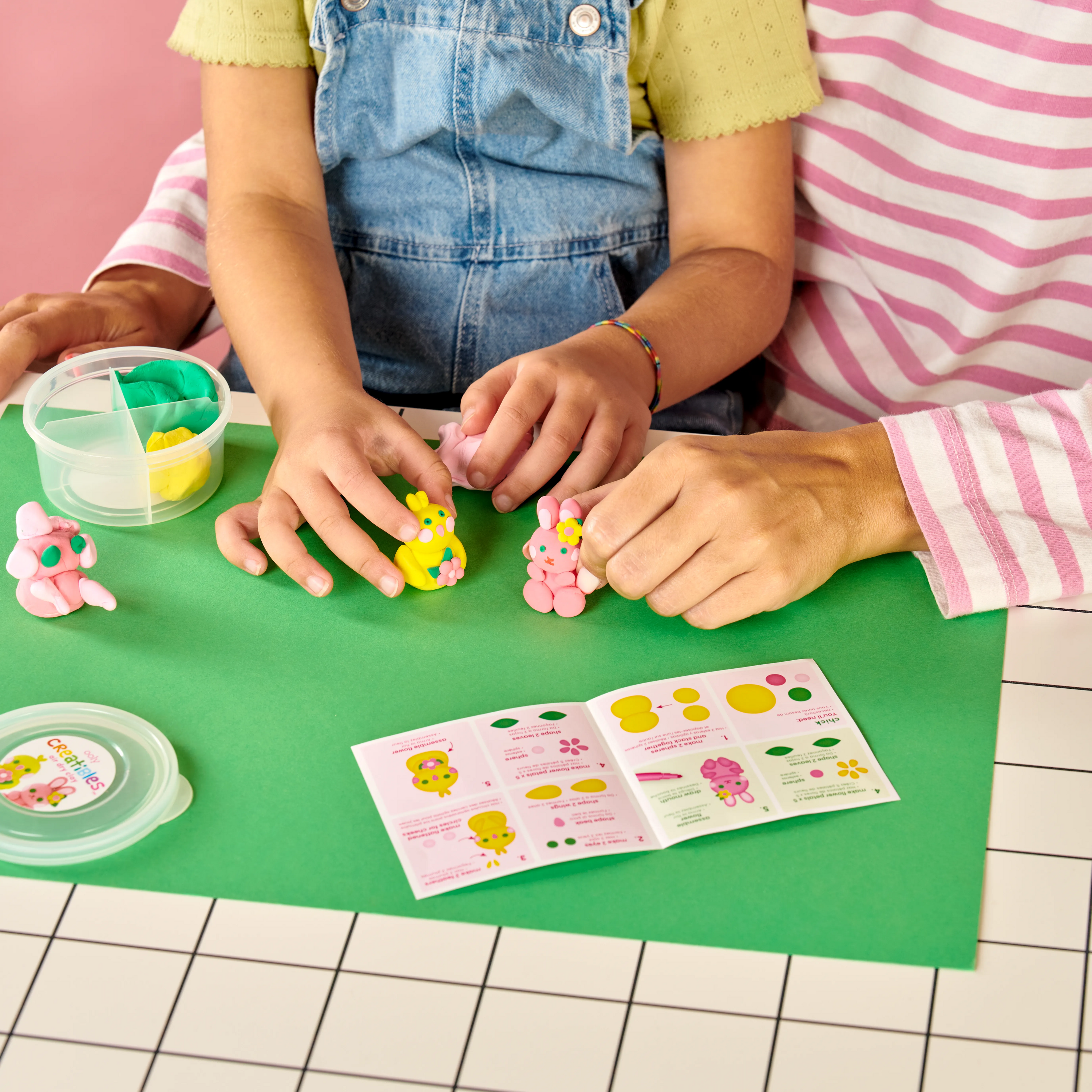 Mom and daughter holding completed chick and bunny from Creatibles Mini Air Dry Clay Kit - Garden Pals BFFs on table top