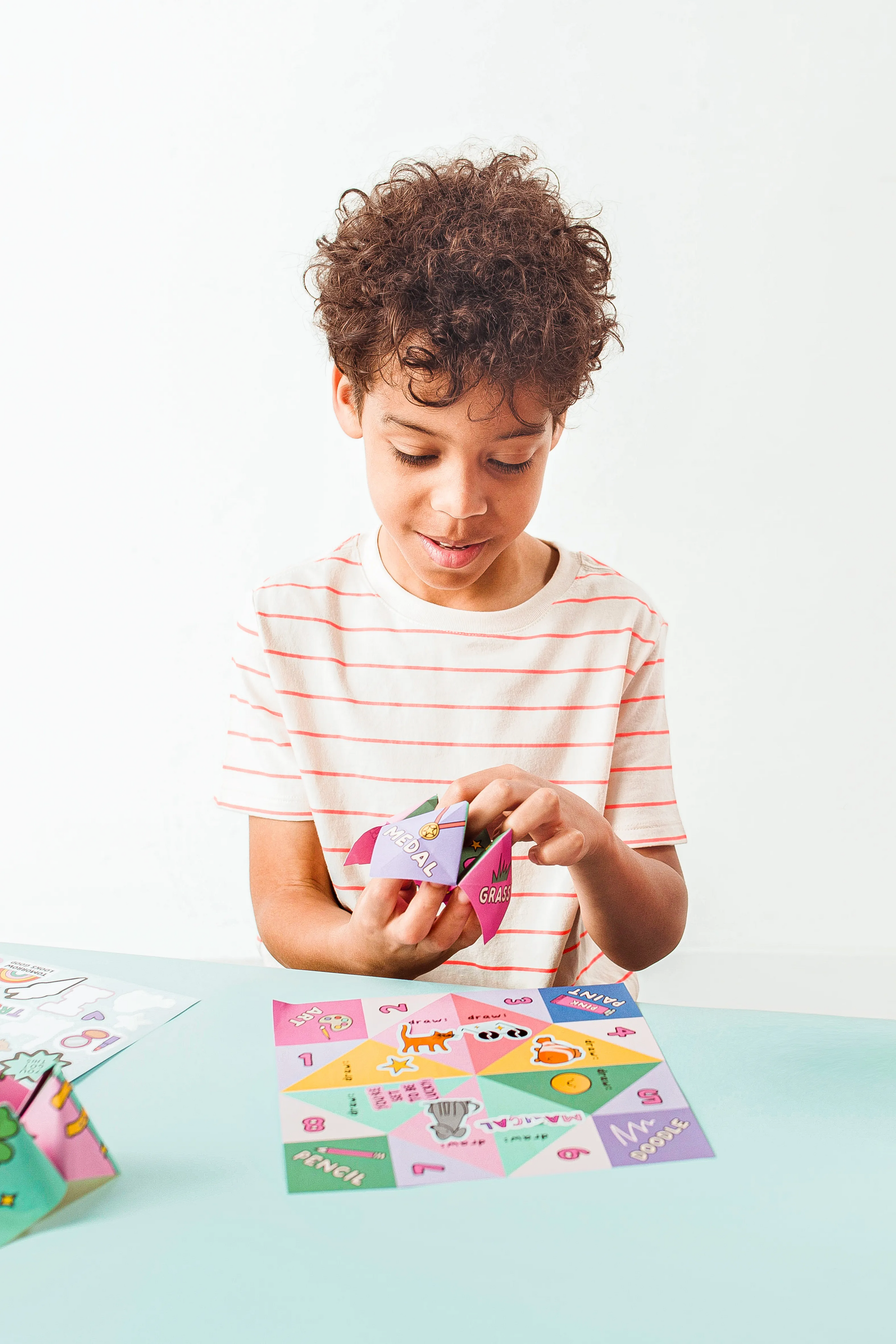 Kid playing with finished OOLY DIY Fortune Teller