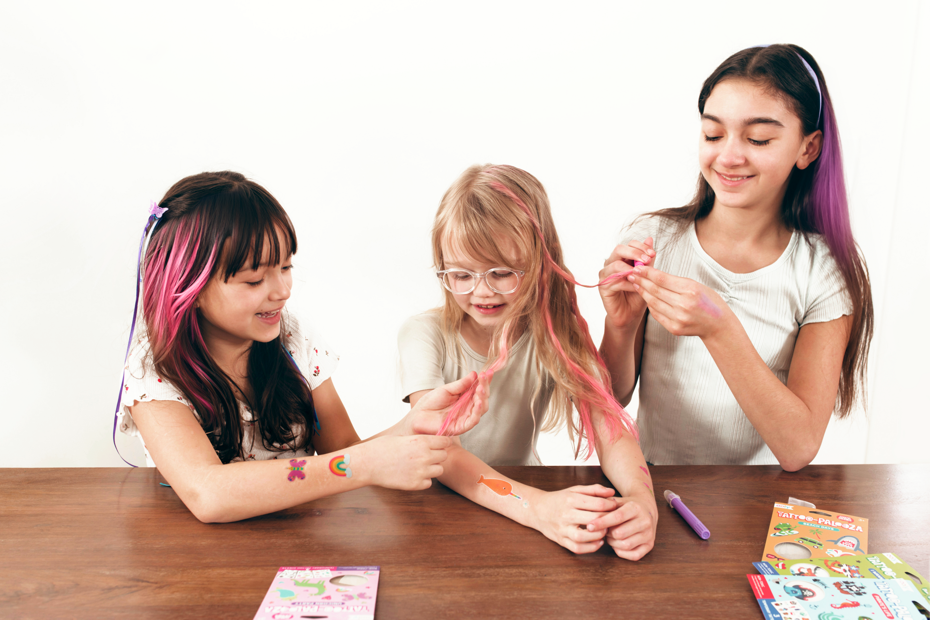 Group of girls coloring hair on girl with OOLY Hair Doodlers Hair Crayons