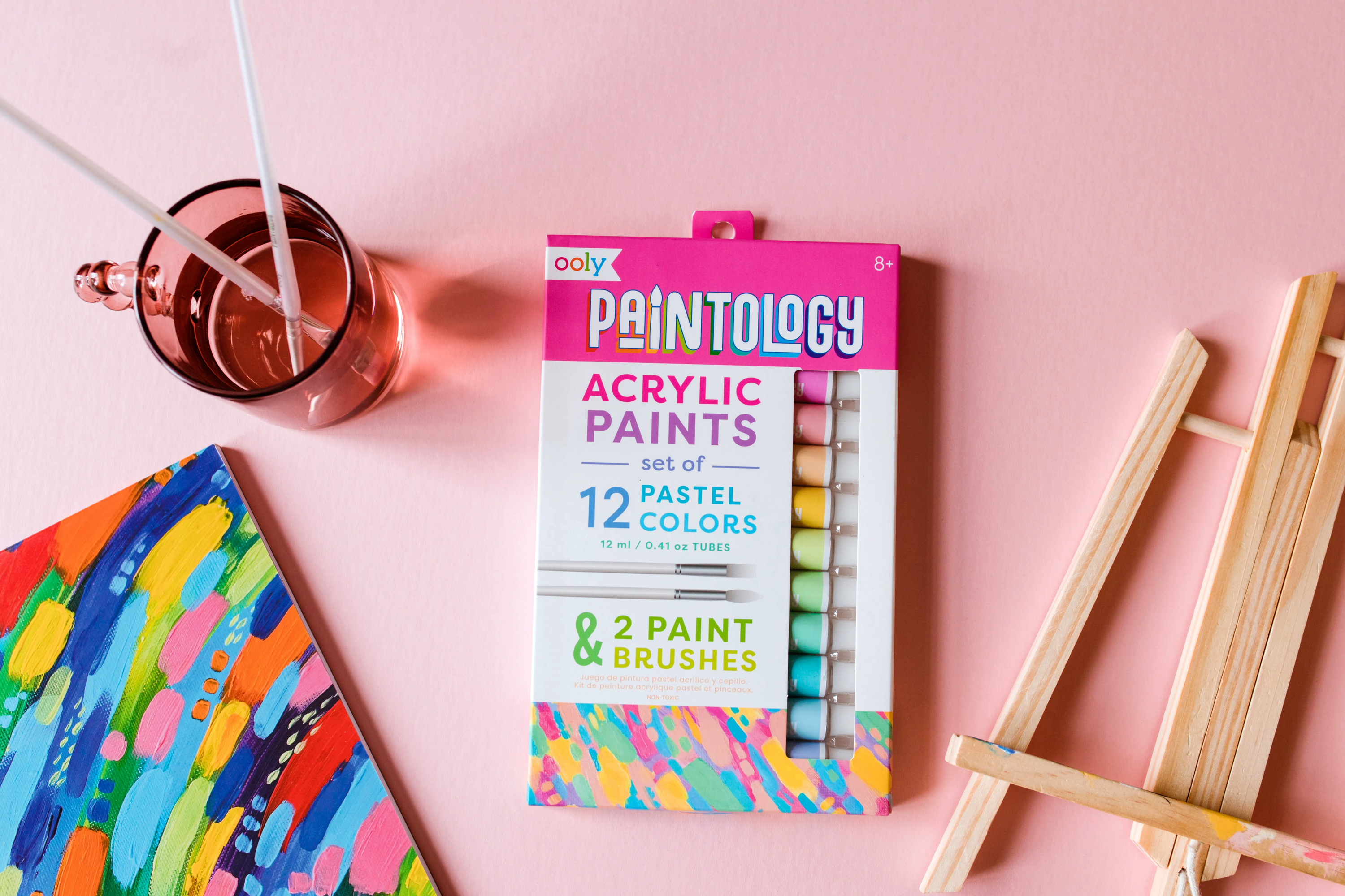 Set of OOLY Paintology Acrylic Pastel Paints with eisel and paint pad on pink background