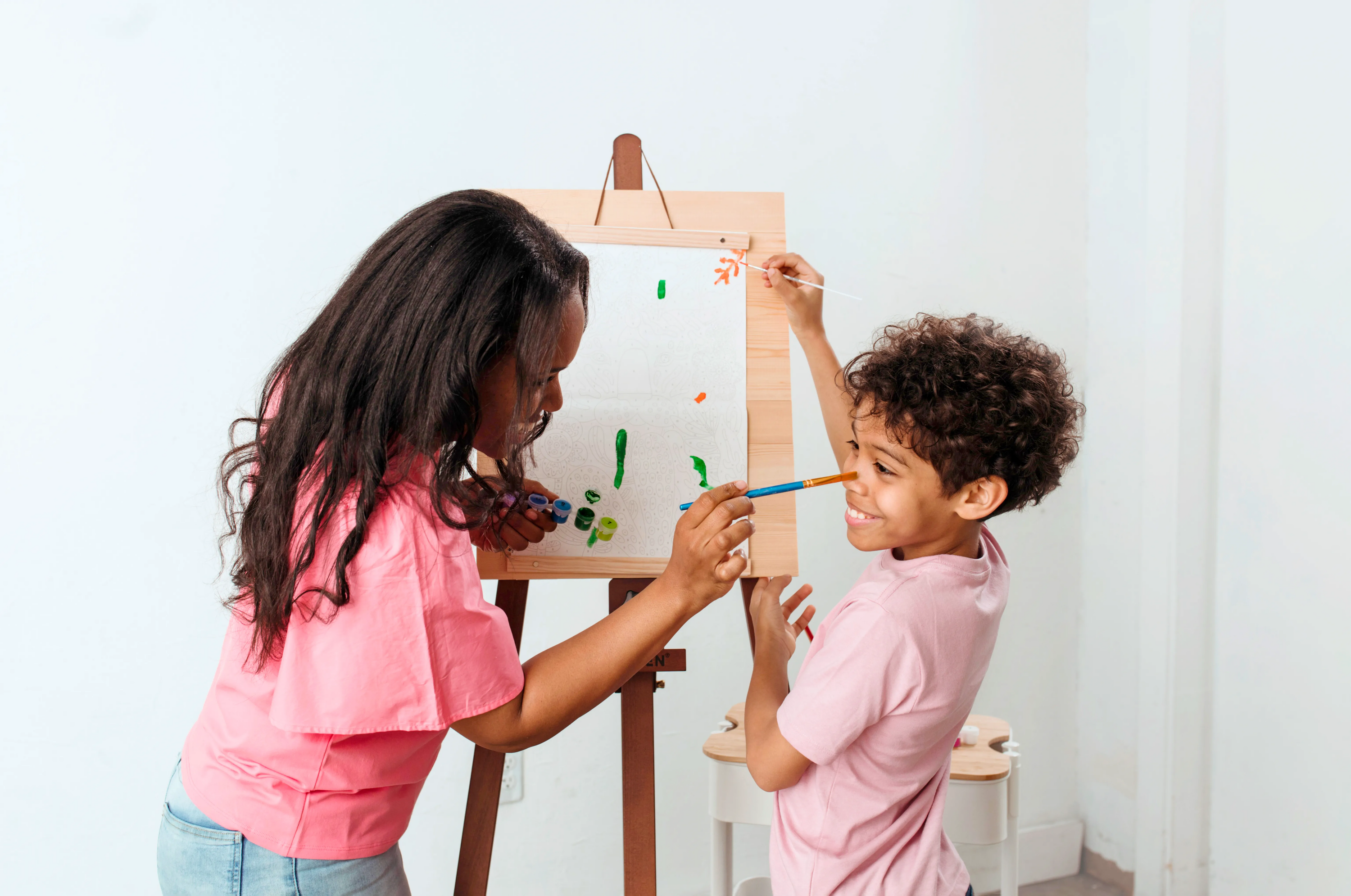 Two kids starting a painting with the Paintology Paint-By-Number Canvas Kit - Tiger Eyes