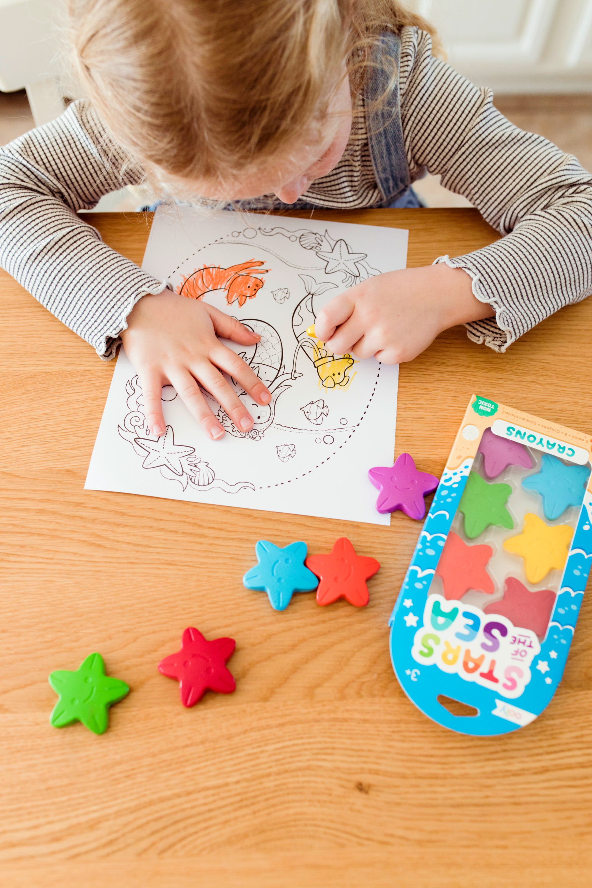 Girl coloring mermaid with Stars of the Sea Crayons